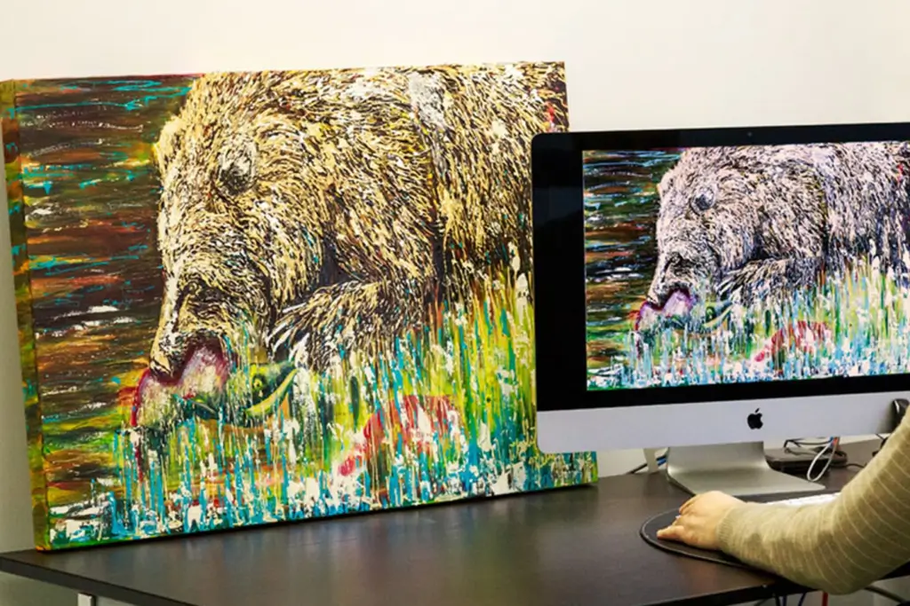 a bear painting on the table and the computer screen